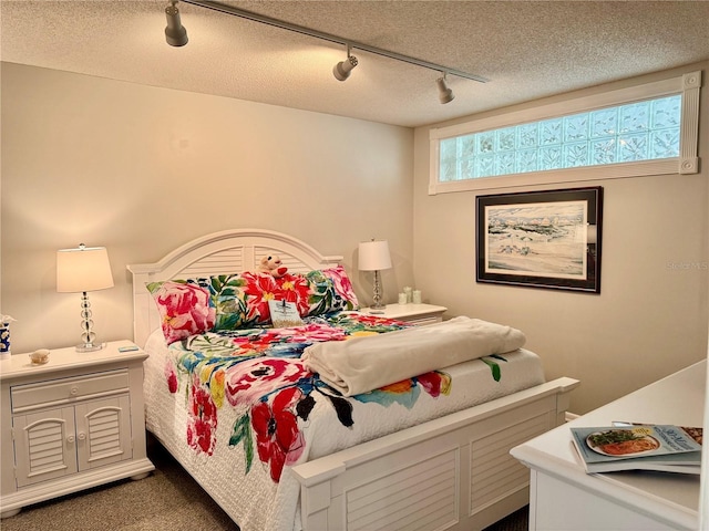 100 Bluff View Dr Unit 105C, Belleair Bluffs, FL 33770 - bedroom featuring rail lighting, a textured ceiling, dark carpet, and ceiling fan