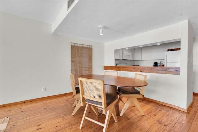 3200 Gulf Blvd Unit 202, St Pete Beach, FL 33706 - dining room featuring light wood-type flooring