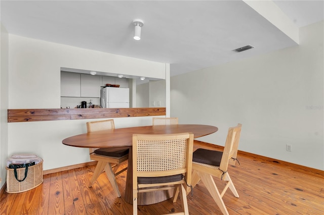 3200 Gulf Blvd Unit 202, St Pete Beach, FL 33706 - dining area with wood finished floors, baseboards, and breakfast area