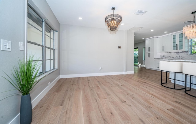 living area with a chandelier, light wood-style flooring, recessed lighting, and baseboards