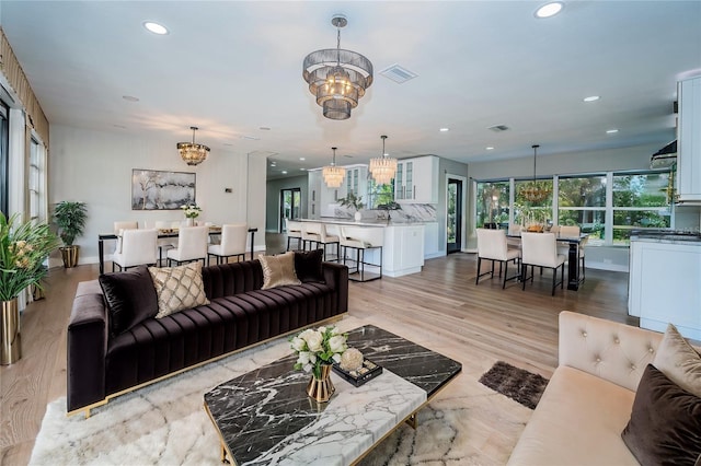 living room with a chandelier, recessed lighting, light wood-type flooring, and baseboards