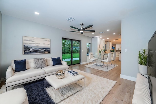 living area featuring a ceiling fan, light wood-style floors, recessed lighting, and baseboards