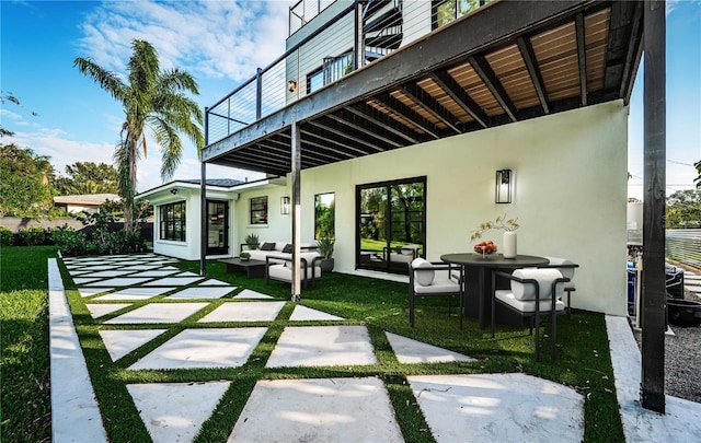 back of house featuring a patio area, an outdoor hangout area, stucco siding, and a yard