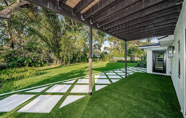 view of green lawn with a patio area