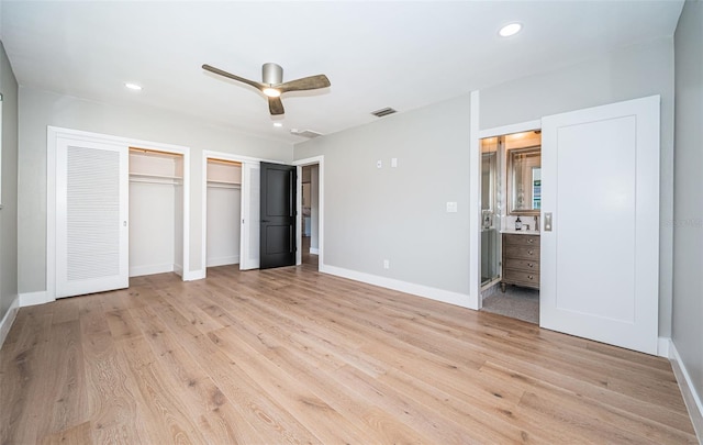 unfurnished bedroom featuring two closets, light wood-style floors, baseboards, recessed lighting, and connected bathroom