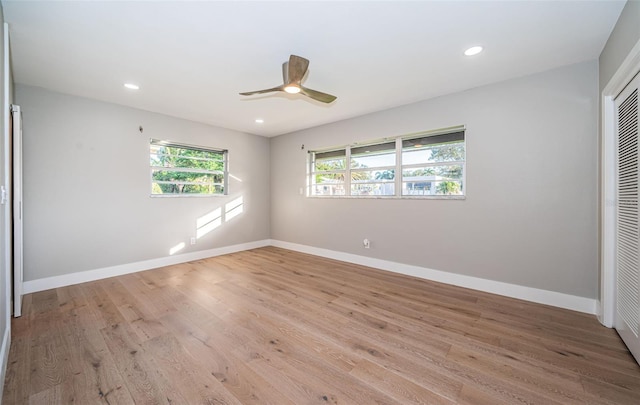 unfurnished bedroom featuring multiple windows, light wood-style floors, a closet, baseboards, and recessed lighting
