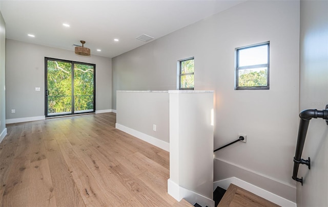 unfurnished room featuring baseboards, plenty of natural light, light wood-style floors, and recessed lighting