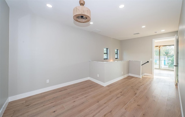 unfurnished room with plenty of natural light, light wood-style floors, recessed lighting, and baseboards