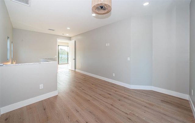 empty room with light wood-style flooring, baseboards, and recessed lighting