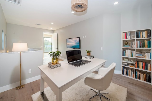 home office featuring light wood finished floors, baseboards, and recessed lighting