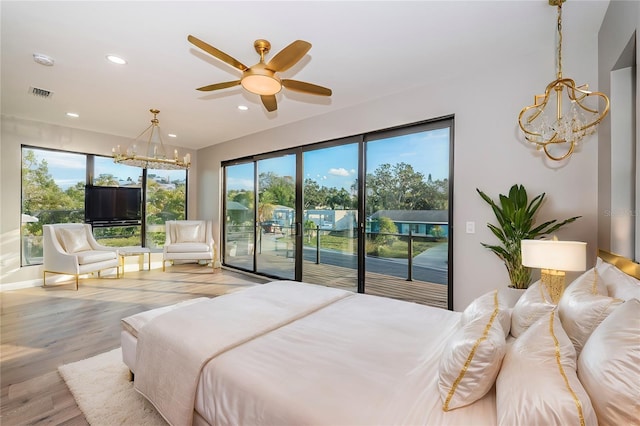 bedroom featuring a chandelier, access to exterior, multiple windows, and recessed lighting
