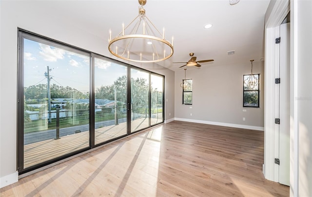 unfurnished room featuring baseboards, a chandelier, wood finished floors, a ceiling fan, and recessed lighting