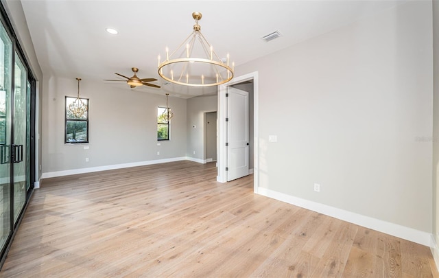 empty room with a chandelier, baseboards, light wood-style floors, and recessed lighting