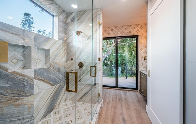 bathroom featuring a stall shower, plenty of natural light, and wood finished floors