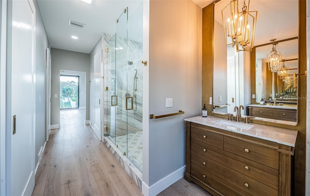 full bath featuring a chandelier, a stall shower, and wood finished floors