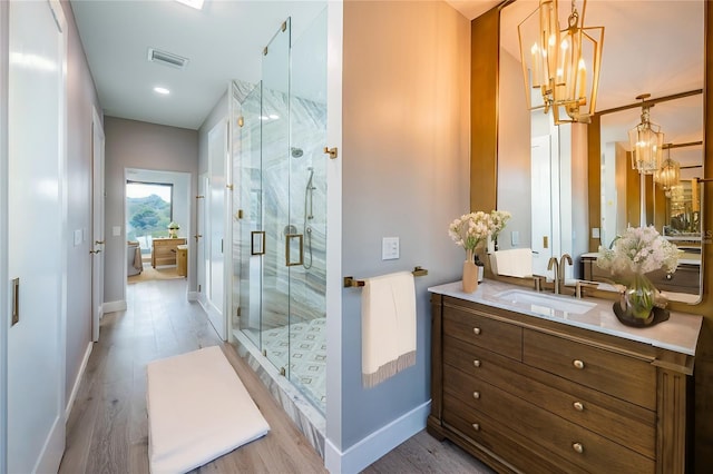 bathroom featuring a chandelier, a shower stall, toilet, and wood finished floors