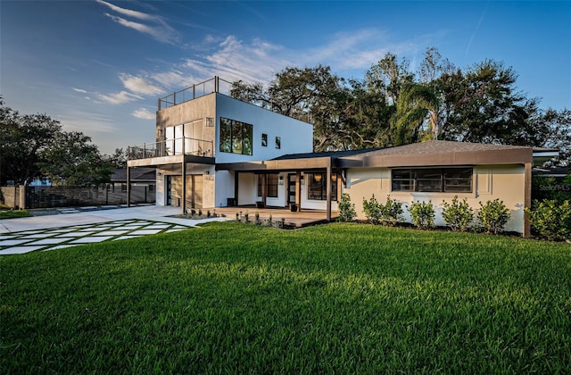 view of front facade featuring concrete driveway, a garage, and a balcony