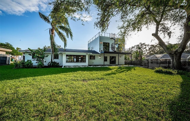 rear view of property with a balcony and stucco siding