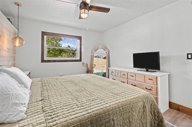 9821 113th St Unit 201, Seminole, FL 33772 - bedroom featuring wood finished floors, a textured ceiling, a ceiling fan, and baseboards