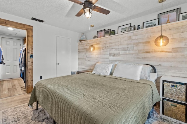 9821 113th St Unit 201, Seminole, FL 33772 - bedroom with wood finished floors, a textured ceiling, and a ceiling fan