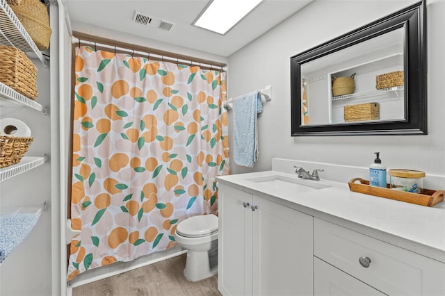 9821 113th St Unit 201, Seminole, FL 33772 - bathroom with wood finished floors, toilet, a shower with shower curtain, and vanity