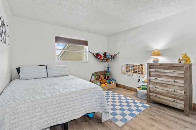 9821 113th St Unit 201, Seminole, FL 33772 - bedroom with wood finished floors, a textured ceiling, and baseboards