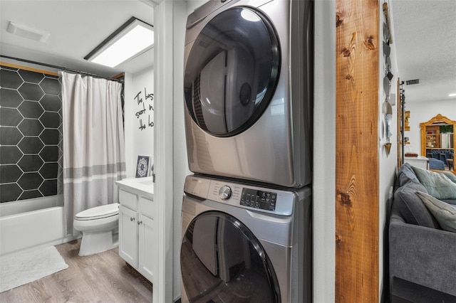 9821 113th St Unit 201, Seminole, FL 33772 - laundry room with stacked washing machine and dryer and light wood-style floors