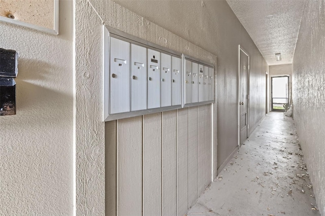 9821 113th St Unit 201, Seminole, FL 33772 - hallway featuring a textured wall, mail area, and a textured ceiling