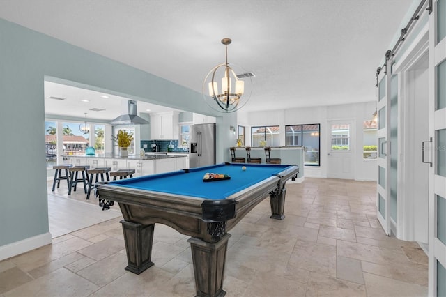 rec room with stone tile floors, pool table, and a chandelier