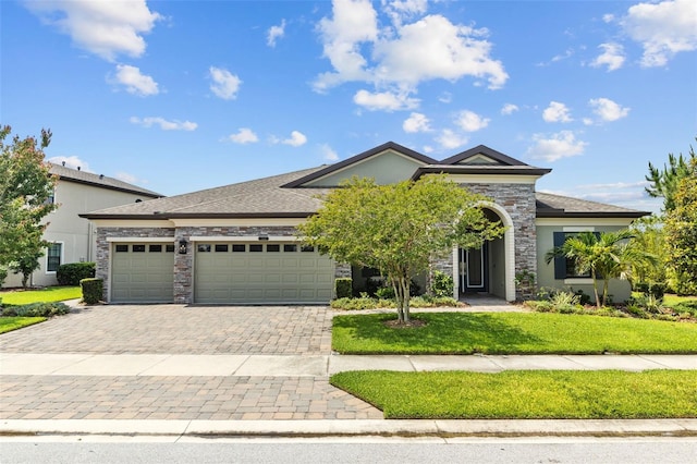 21642 Emory Oak Pl, Land O Lakes, FL 34637 - view of front facade featuring a garage, decorative driveway, a front yard, and stucco siding