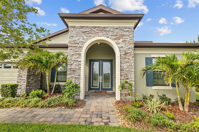 21642 Emory Oak Pl, Land O Lakes, FL 34637 - entrance to property featuring stone siding, stucco siding, french doors, and an attached garage