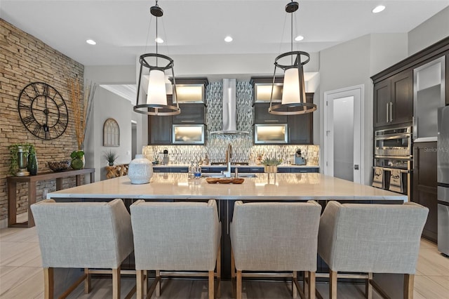 21642 Emory Oak Pl, Land O Lakes, FL 34637 - kitchen featuring wall chimney range hood, tasteful backsplash, a large island, decorative light fixtures, and recessed lighting