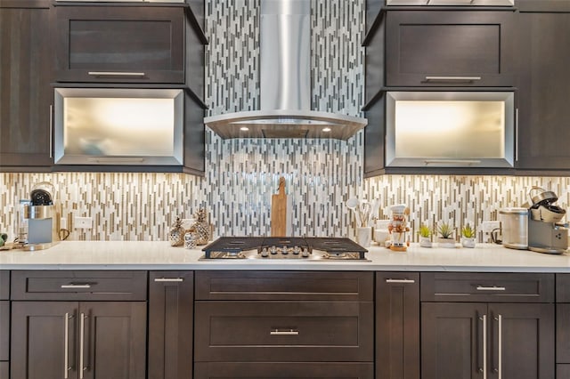 21642 Emory Oak Pl, Land O Lakes, FL 34637 - kitchen featuring wall chimney exhaust hood, stainless steel gas cooktop, light countertops, decorative backsplash, and dark brown cabinets