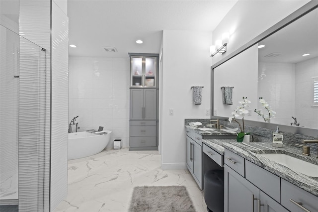 21642 Emory Oak Pl, Land O Lakes, FL 34637 - bathroom featuring double vanity, marble finish flooring, a soaking tub, a stall shower, and recessed lighting