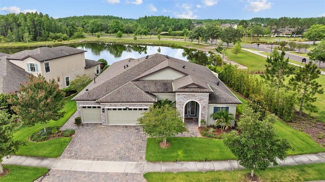 21642 Emory Oak Pl, Land O Lakes, FL 34637 - view of front of property with a water view, an attached garage, decorative driveway, stone siding, and a front lawn