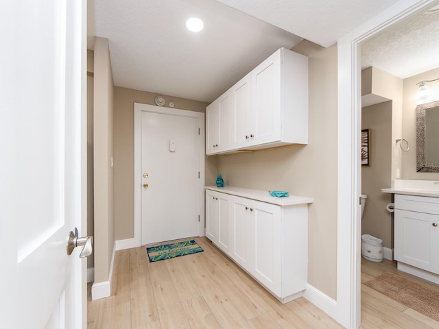 washroom featuring light wood-type flooring, baseboards, and recessed lighting