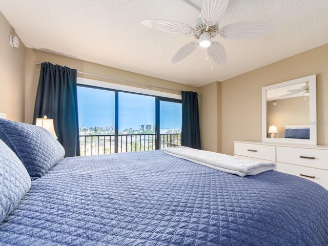 bedroom with access to outside, a textured ceiling, and a ceiling fan