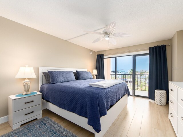bedroom with access to outside, light wood-style floors, and a ceiling fan
