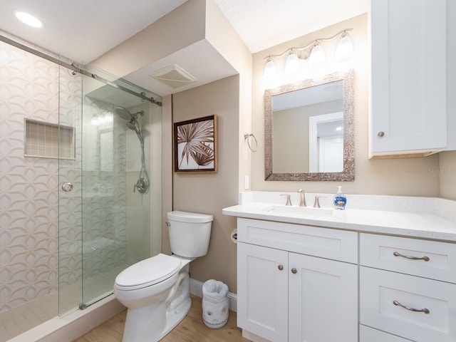 full bathroom featuring a stall shower, toilet, baseboards, vanity, and wood finished floors