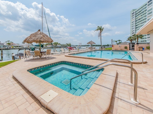 community pool with a hot tub and a patio
