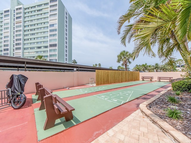 view of property's community with shuffleboard and fence