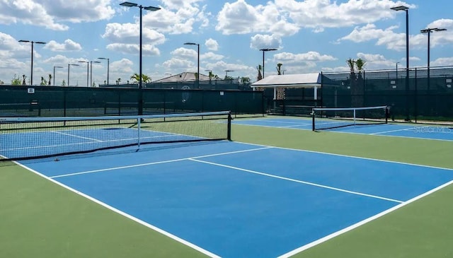 view of tennis court with fence and community basketball court