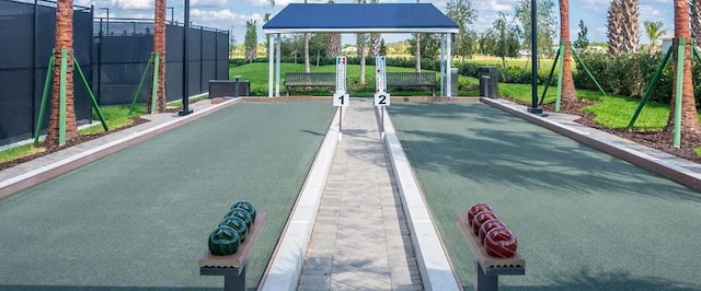 view of property's community with a bocce ball area and fence