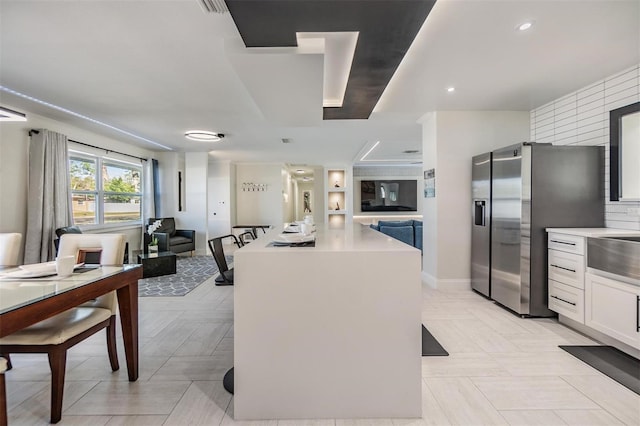 5744 150th Ave N, Clearwater, FL 33760 - kitchen with stainless steel refrigerator with ice dispenser, white cabinets, a center island, light countertops, and open floor plan