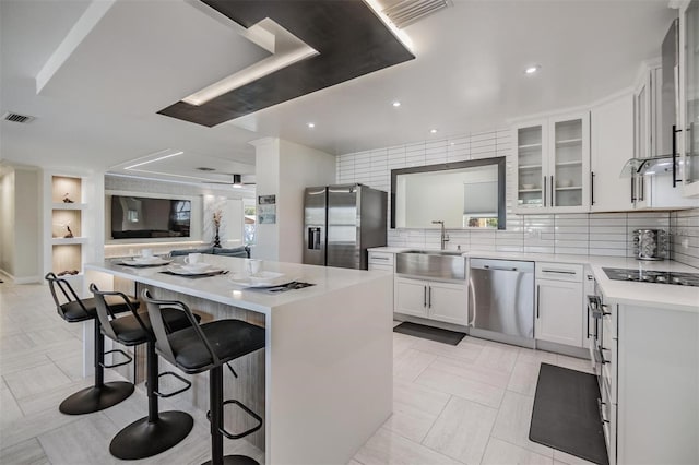 5744 150th Ave N, Clearwater, FL 33760 - kitchen featuring appliances with stainless steel finishes, a sink, light countertops, a kitchen breakfast bar, and glass insert cabinets