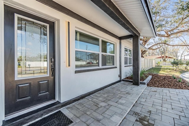 5744 150th Ave N, Clearwater, FL 33760 - doorway to property featuring stucco siding and a patio