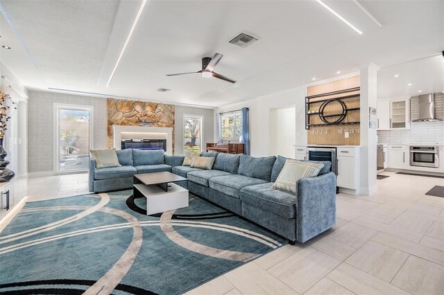 5744 150th Ave N, Clearwater, FL 33760 - living area featuring healthy amount of natural light, a glass covered fireplace, ceiling fan, and beverage cooler