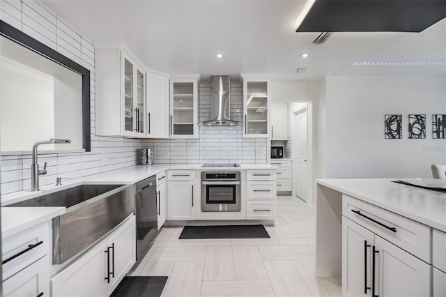5744 150th Ave N, Clearwater, FL 33760 - kitchen featuring stainless steel appliances, wall chimney range hood, a sink, backsplash, and white cabinets