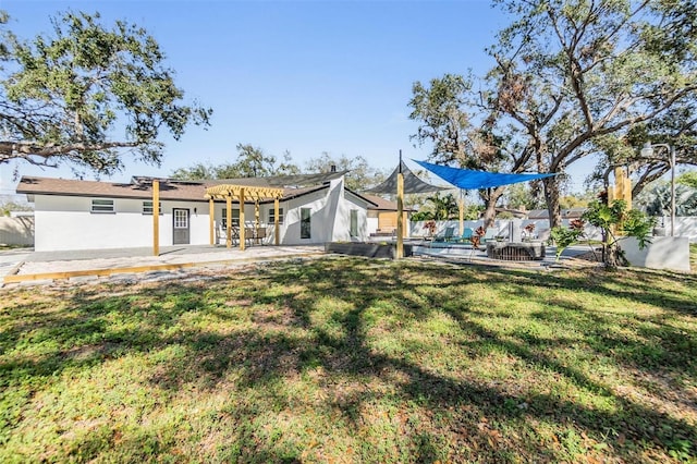 5744 150th Ave N, Clearwater, FL 33760 - back of house featuring a patio, stucco siding, a lawn, and a pergola
