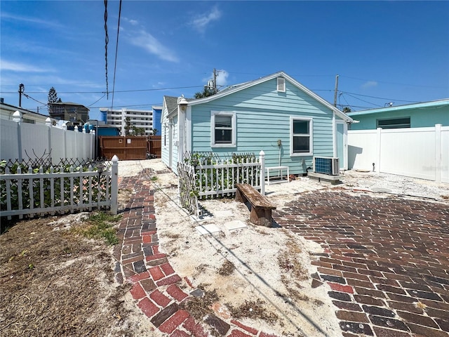 13326 1st St E, Madeira Beach, FL 33708 - back of house featuring cooling unit, a fenced backyard, and a patio